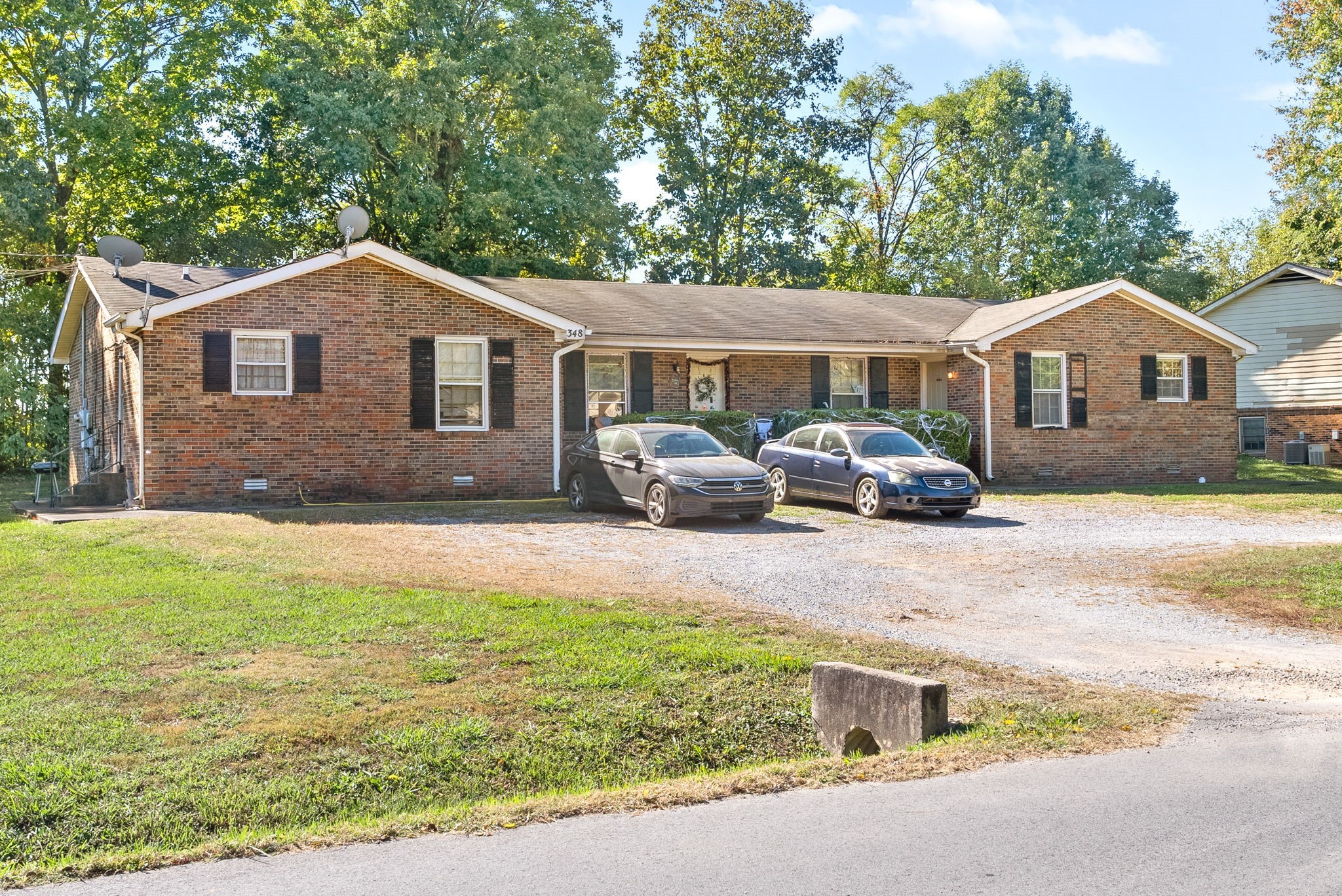 a front view of house with yard and trees around