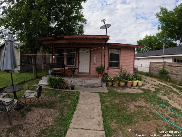 a view of house with a yard and furniture