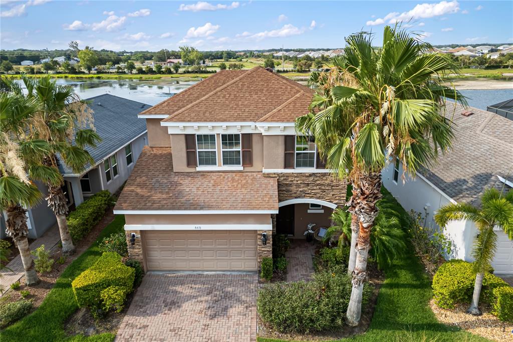 a aerial view of a house with a yard and a large tree