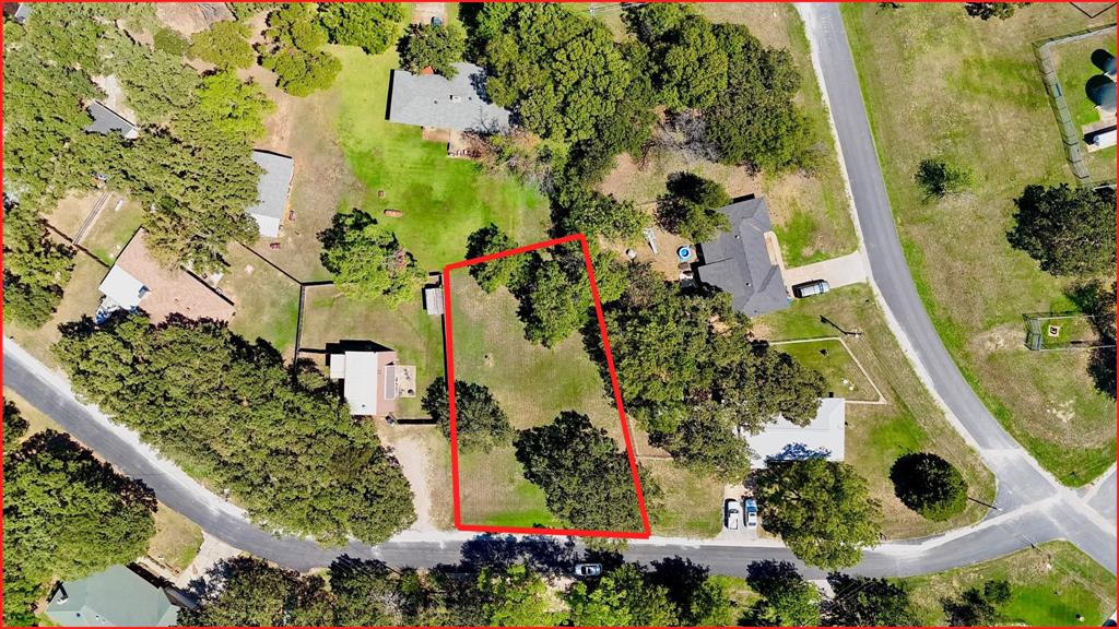 an aerial view of residential house with outdoor space and trees all around