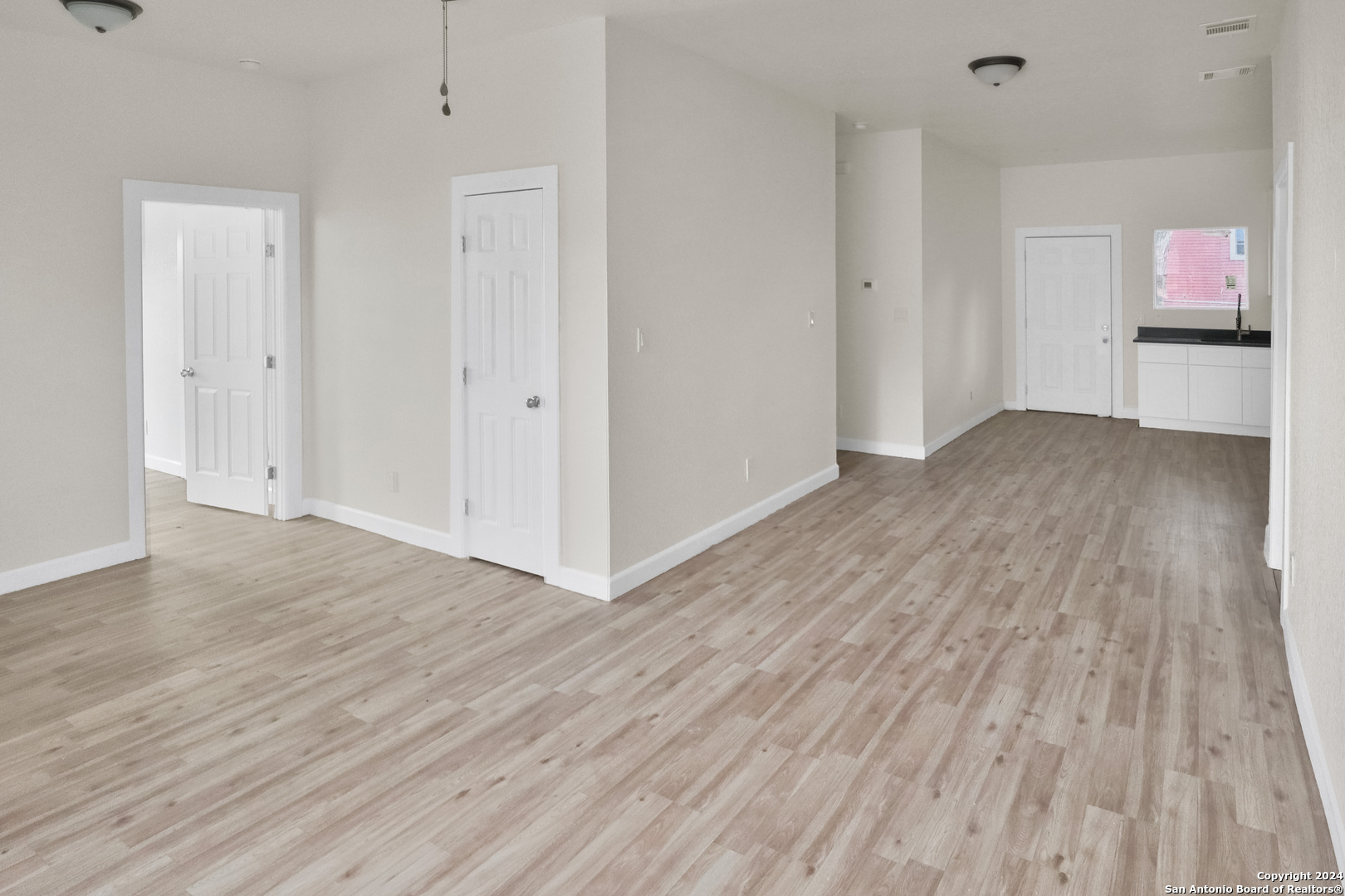 a view of a room with wooden floor and a window