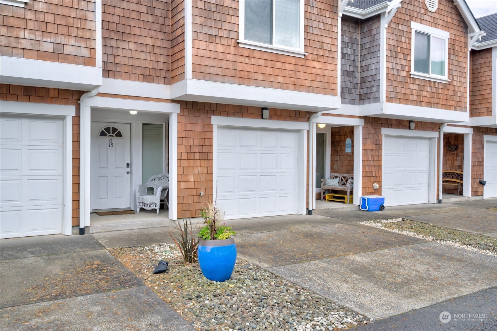 a view of a brick house with potted plants in front of door