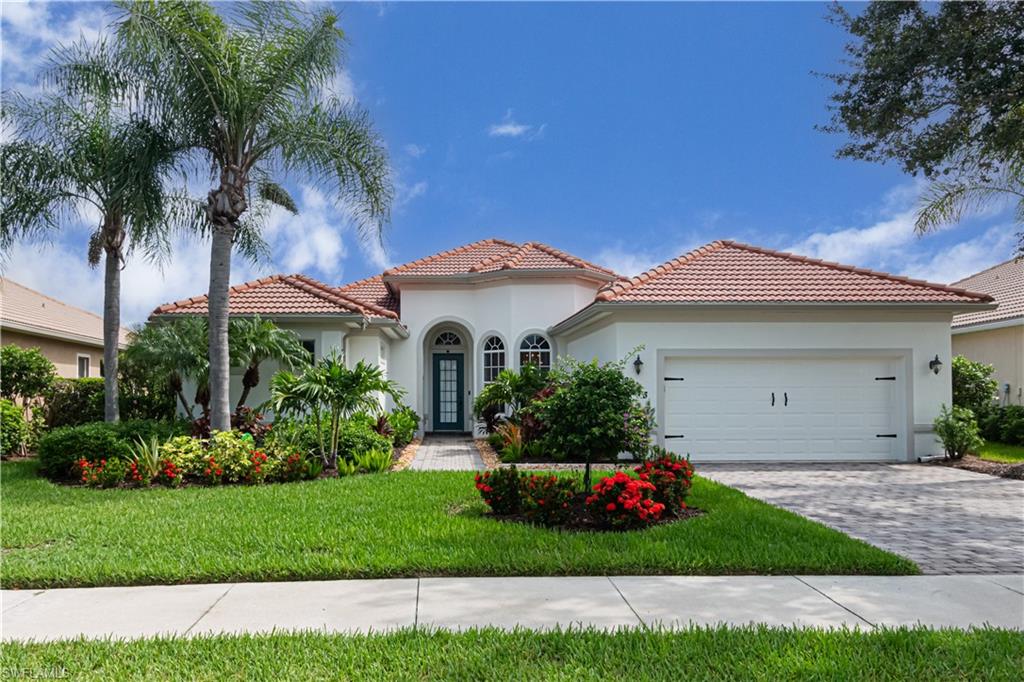 a front view of a house with a garden and plants