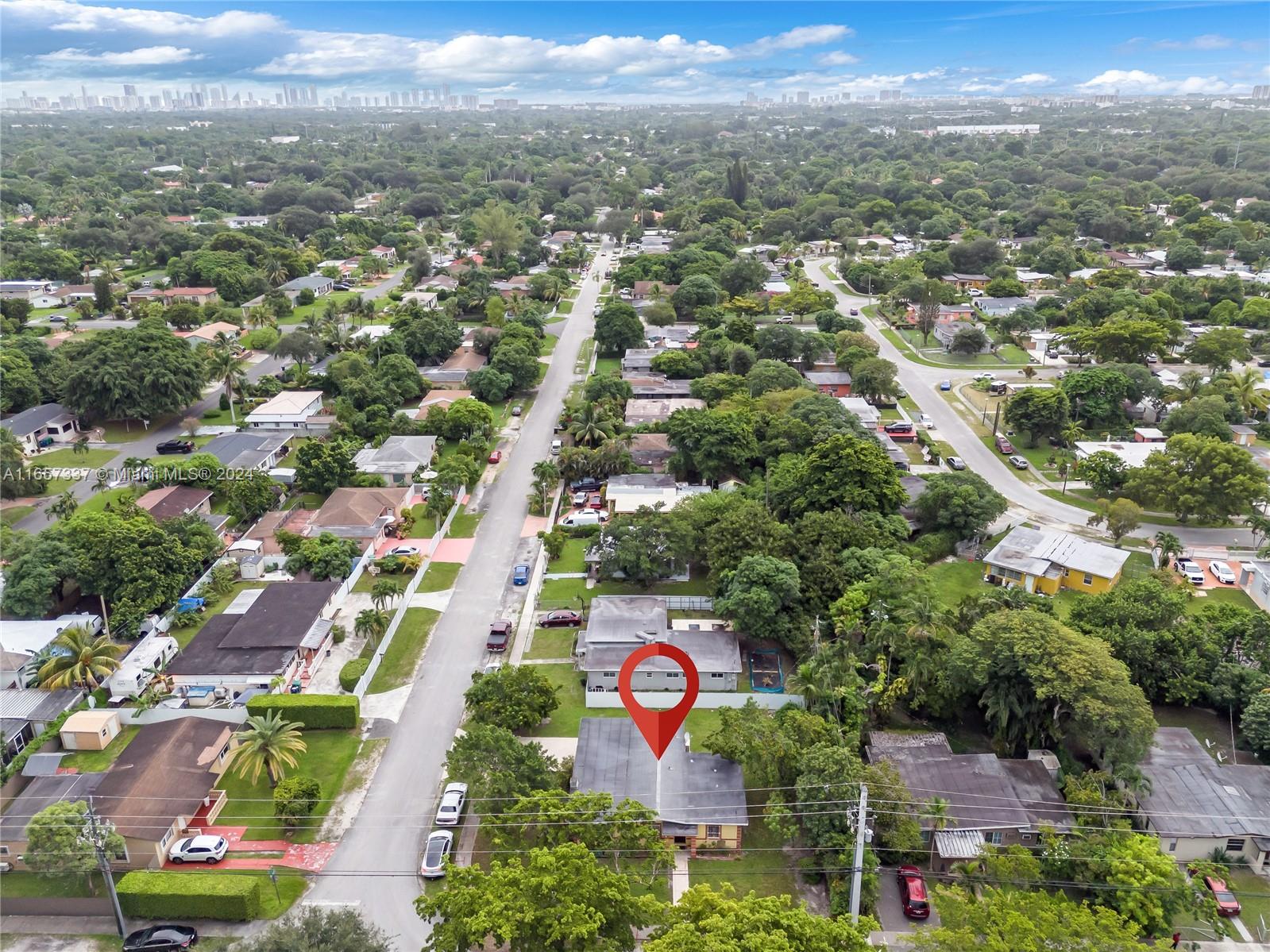 an aerial view of residential houses with outdoor space and trees