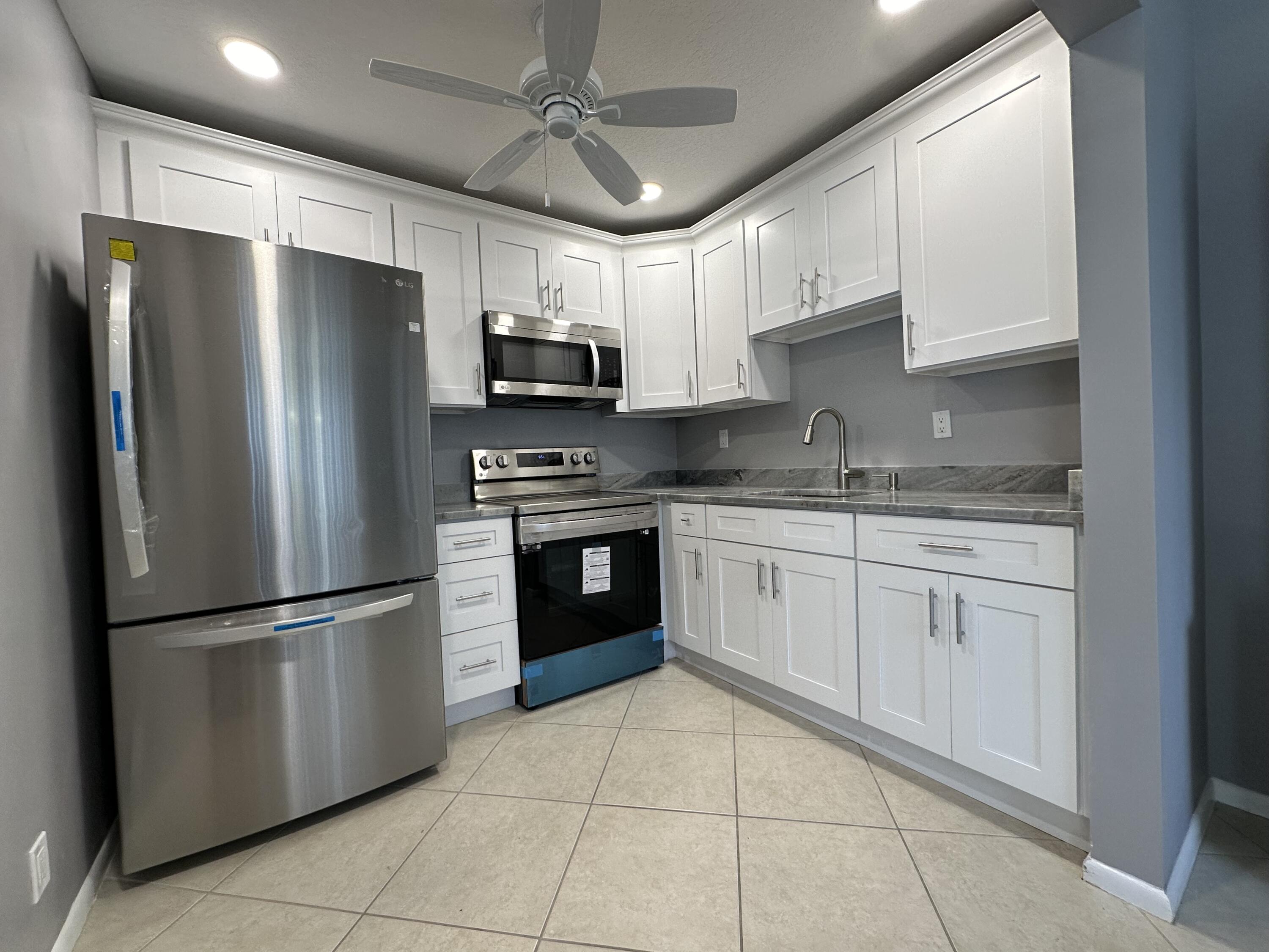 a kitchen with stainless steel appliances granite countertop a refrigerator sink and cabinets