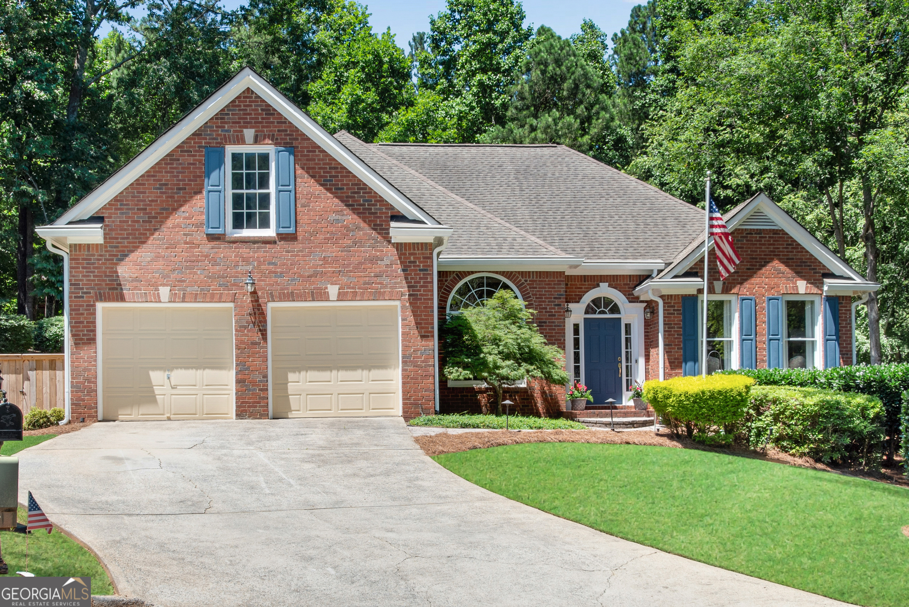 a front view of a house with a yard and trees