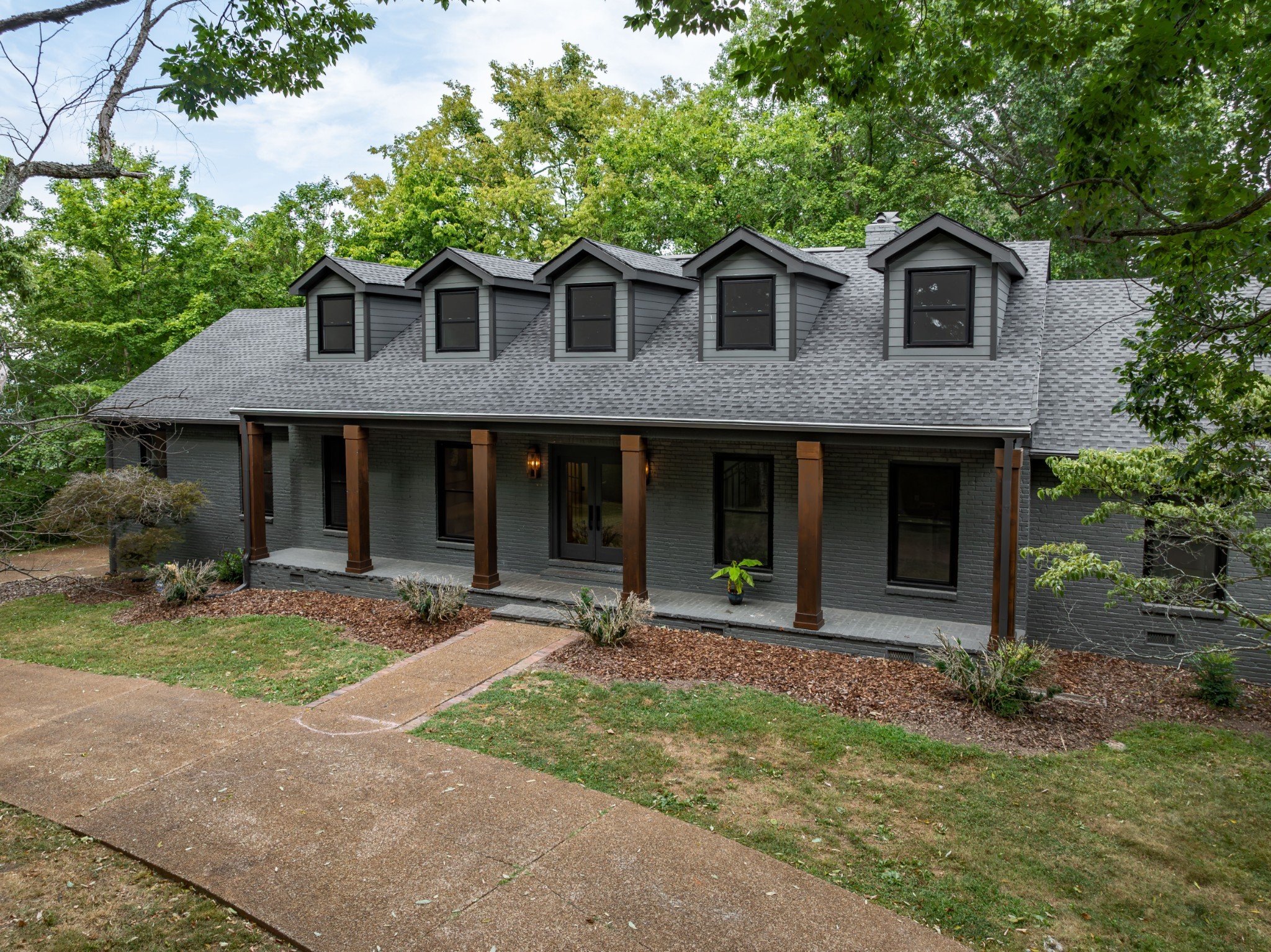 a front view of a house with garden and porch