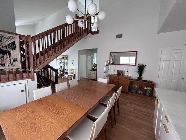 a dining room with wooden floor and a chandelier