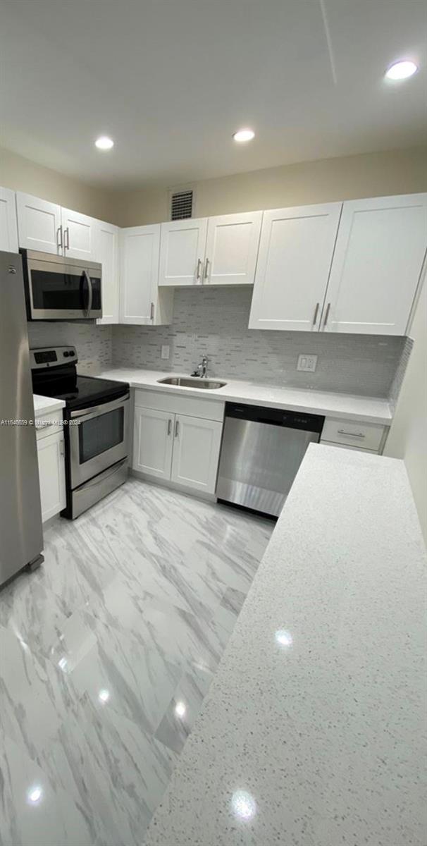 a kitchen with stainless steel appliances a sink and a stove top oven