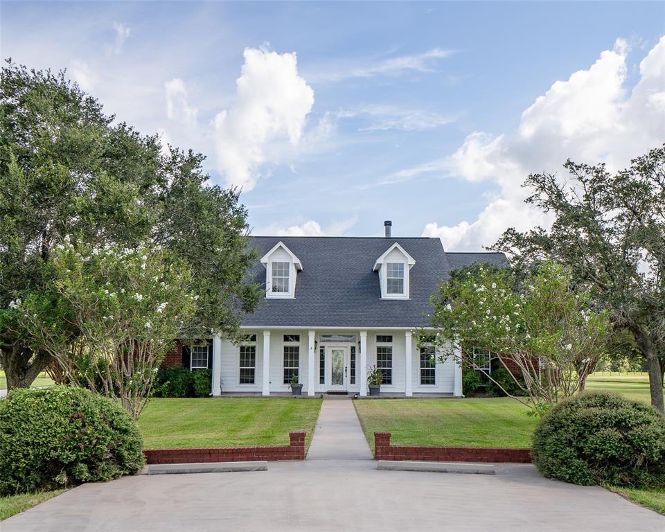 a front view of a house with a garden and trees