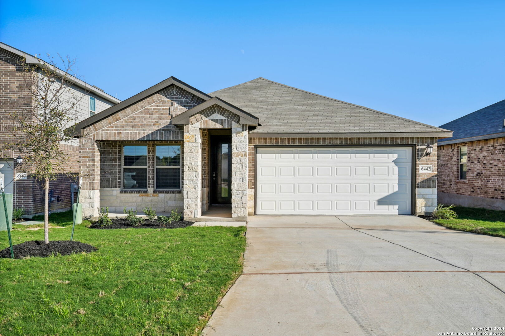 a front view of a house with a garden and yard