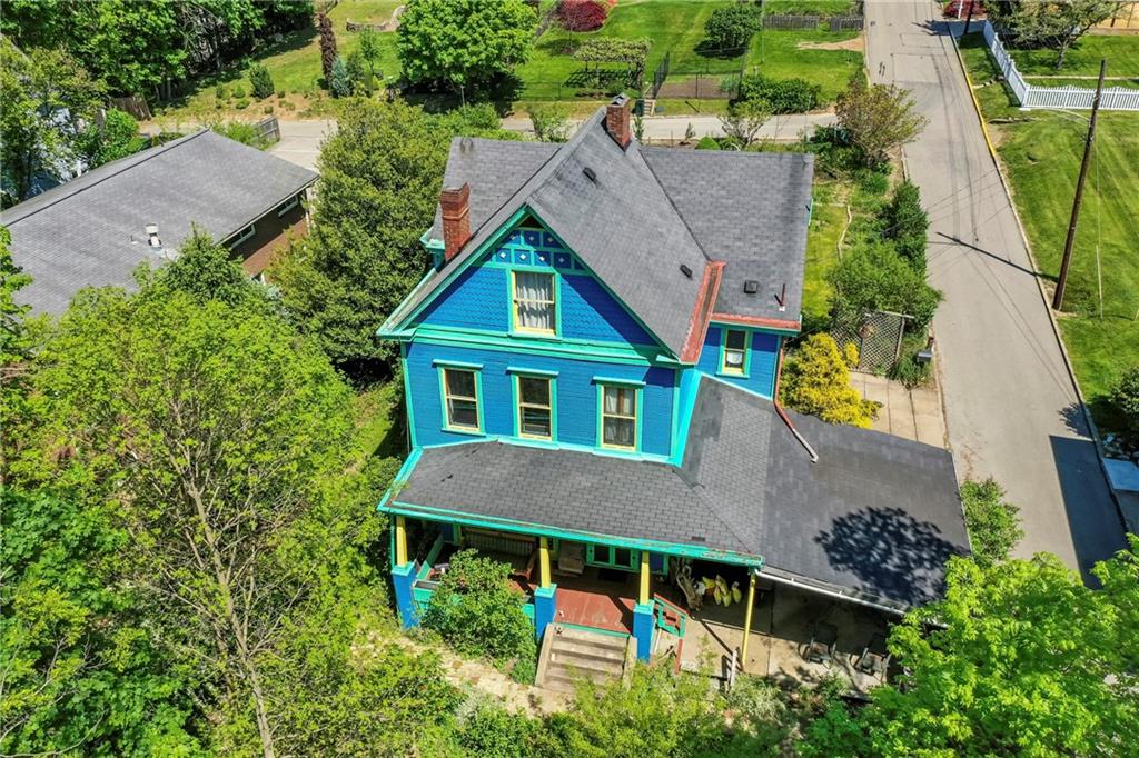 an aerial view of house with swimming pool and garden