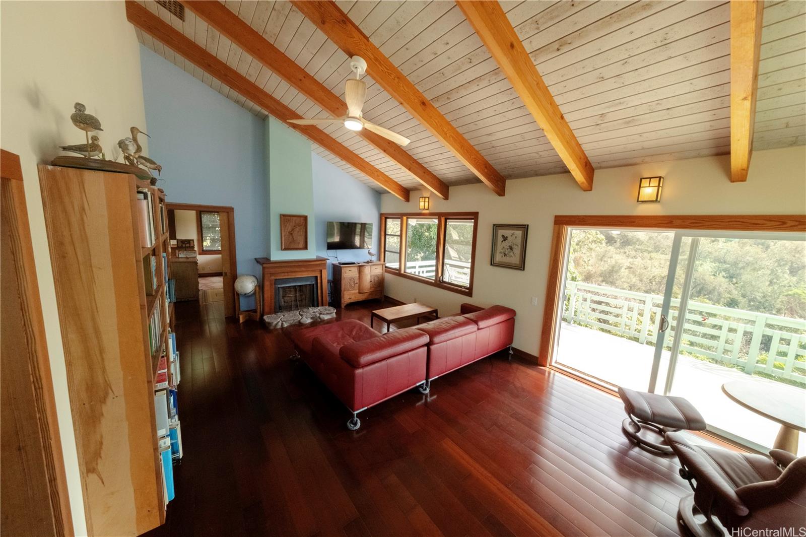 a living room with furniture large window and wooden floor