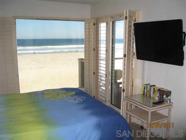 a bedroom with a bed and large windows