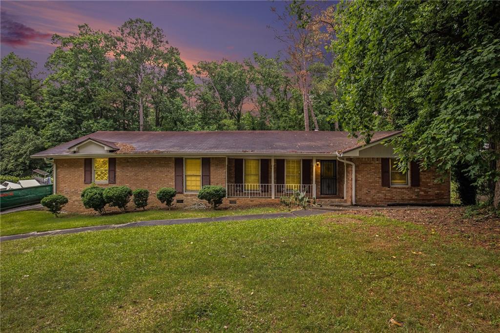 a front view of a house with a yard and trees