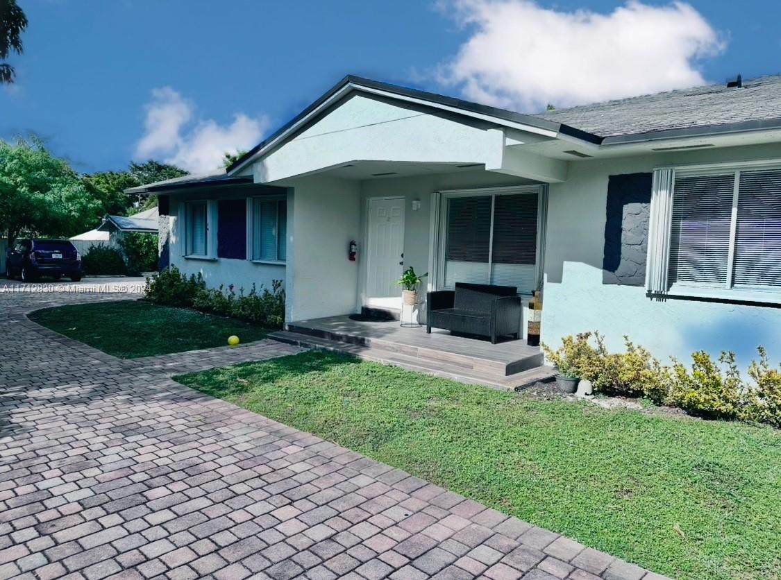 a front view of a house with a garden and plants