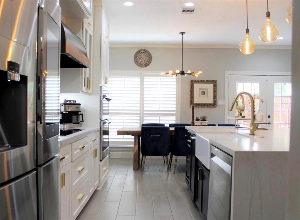 a kitchen with stainless steel appliances granite countertop a sink a stove and a refrigerator