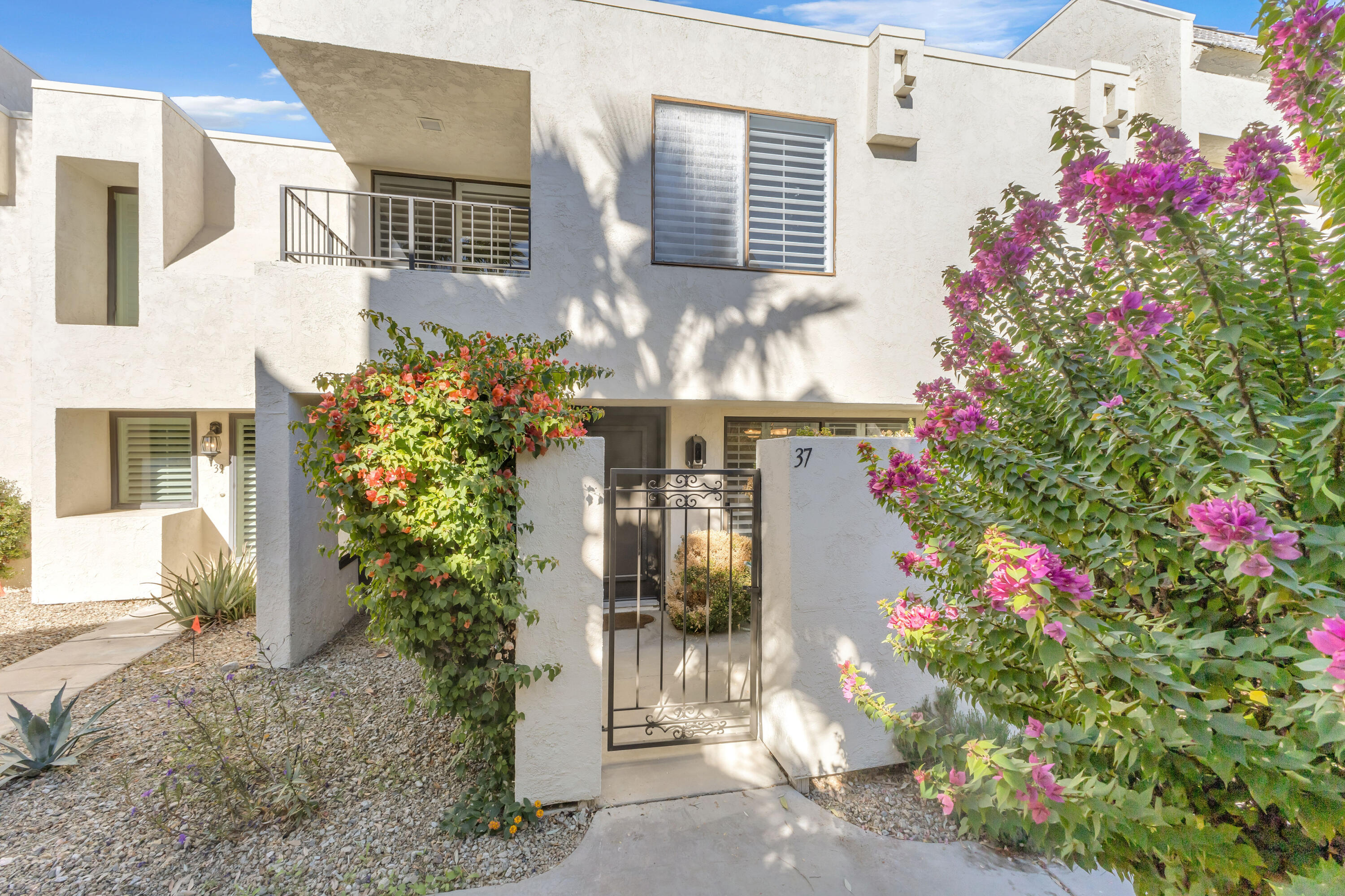 a front view of a house with lots of flowers