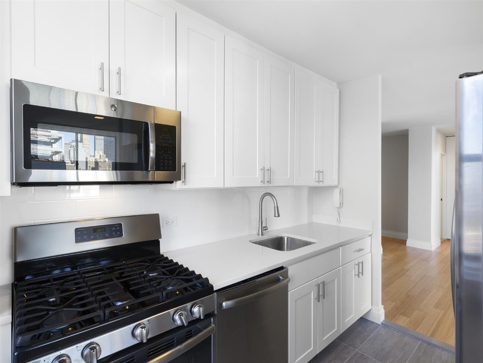 a kitchen with stainless steel appliances granite countertop a stove and a microwave