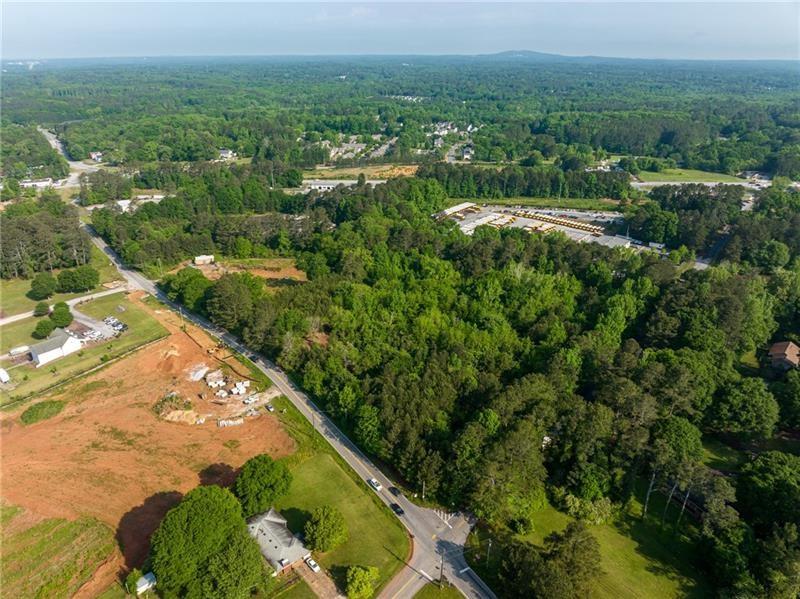 an aerial view of residential houses with outdoor space and trees