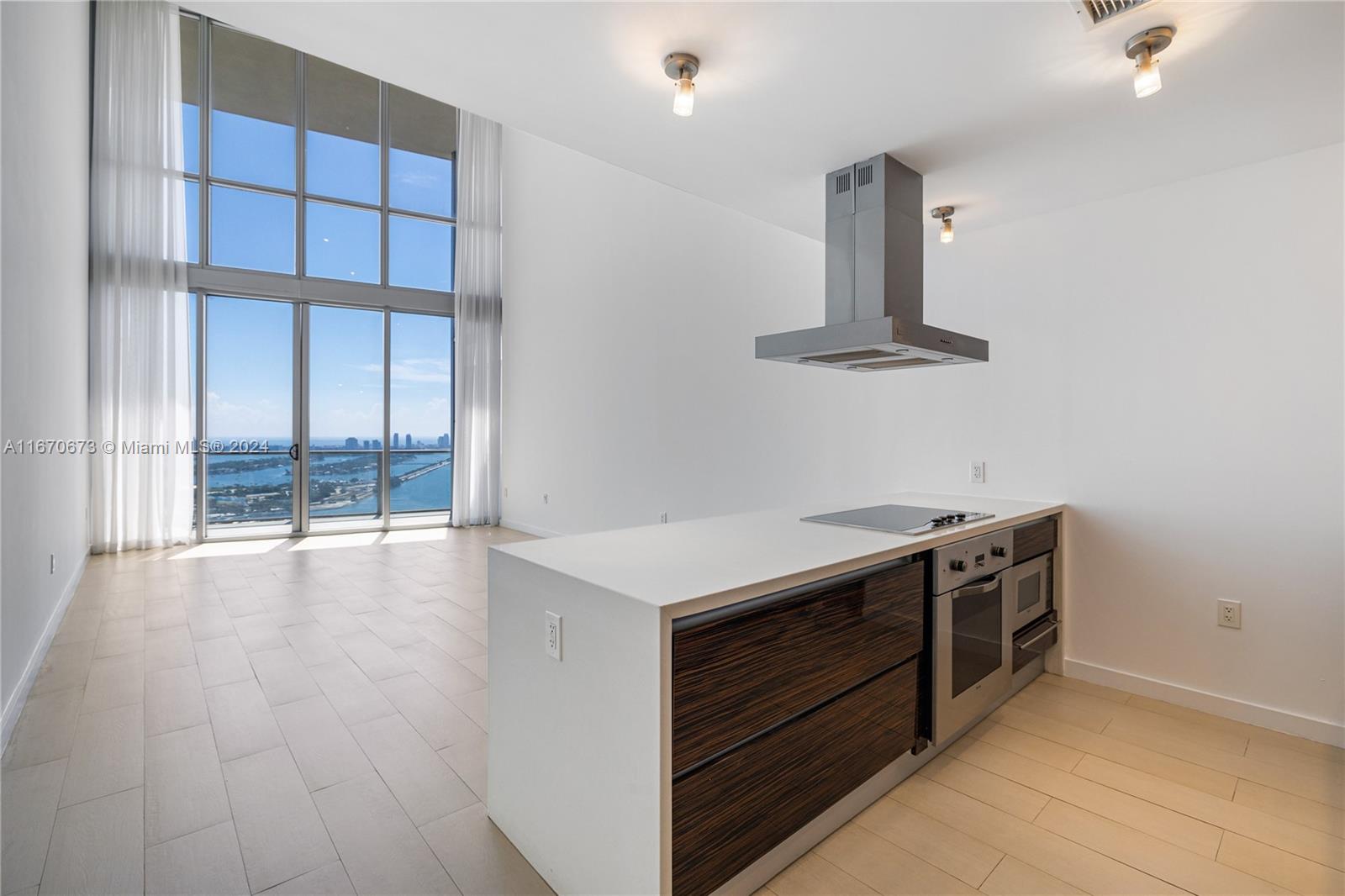 a kitchen with stainless steel appliances a stove and a large window