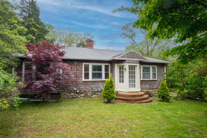 a front view of a house with a garden and yard