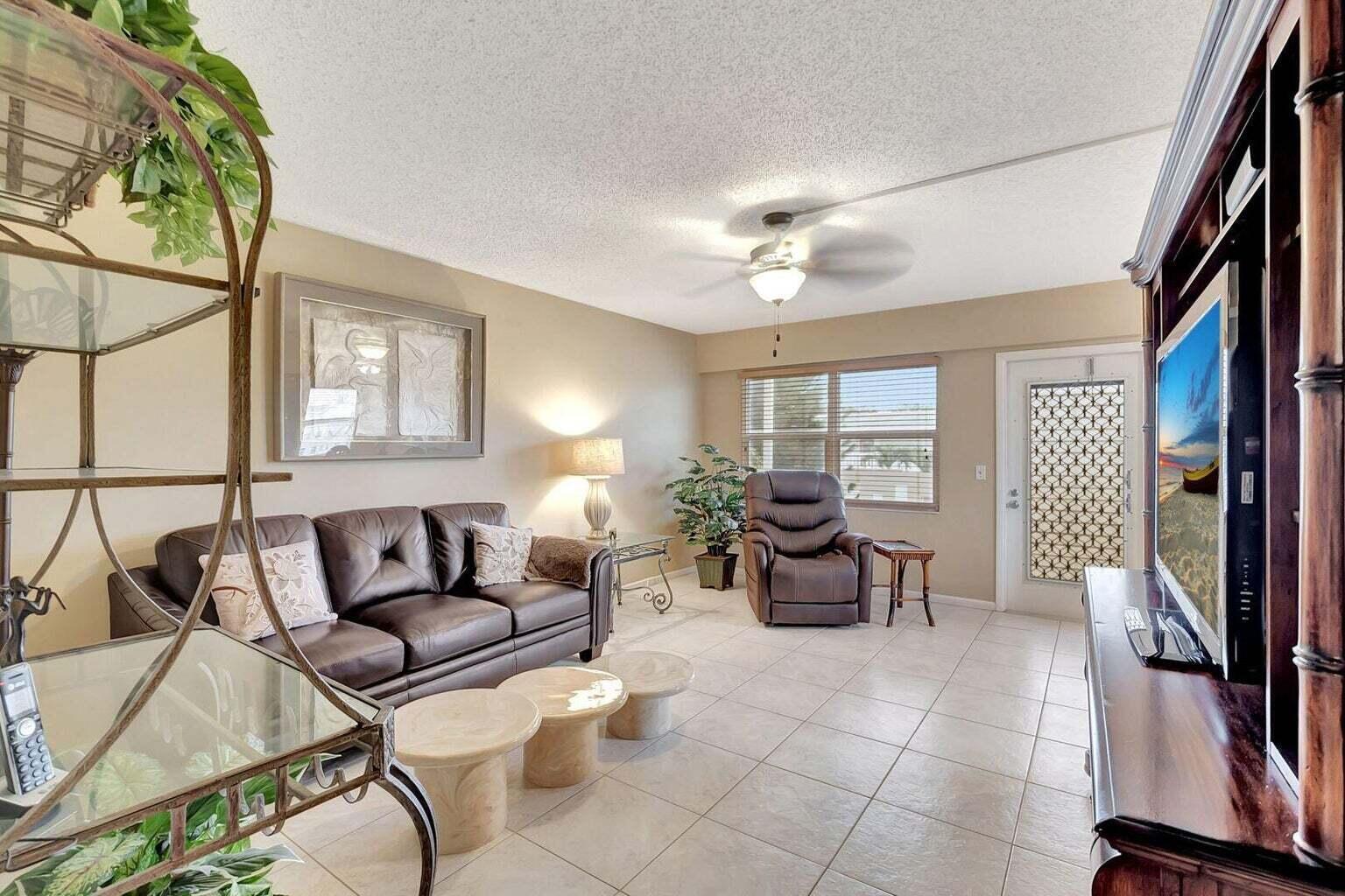 a living room with furniture a flat screen tv and a window