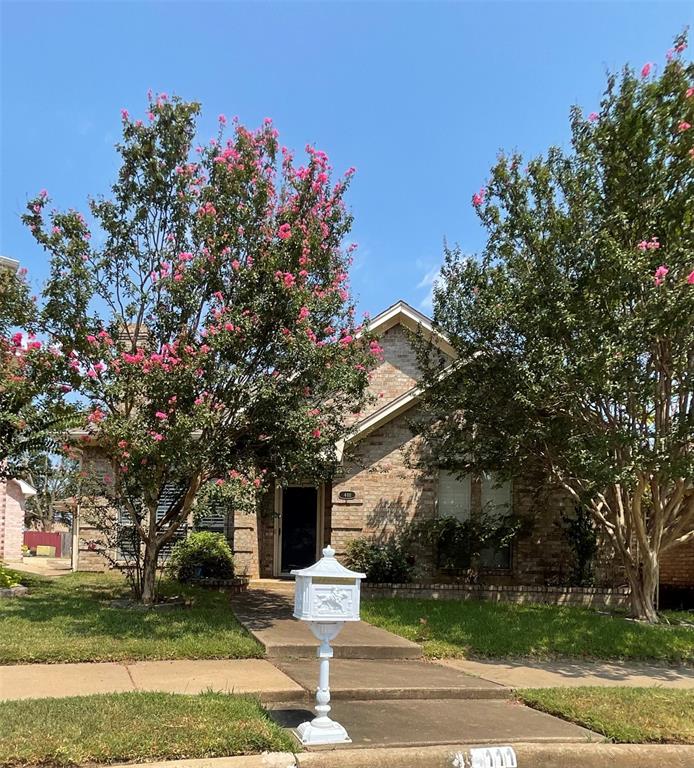 a front view of a house with a yard garage and fountain