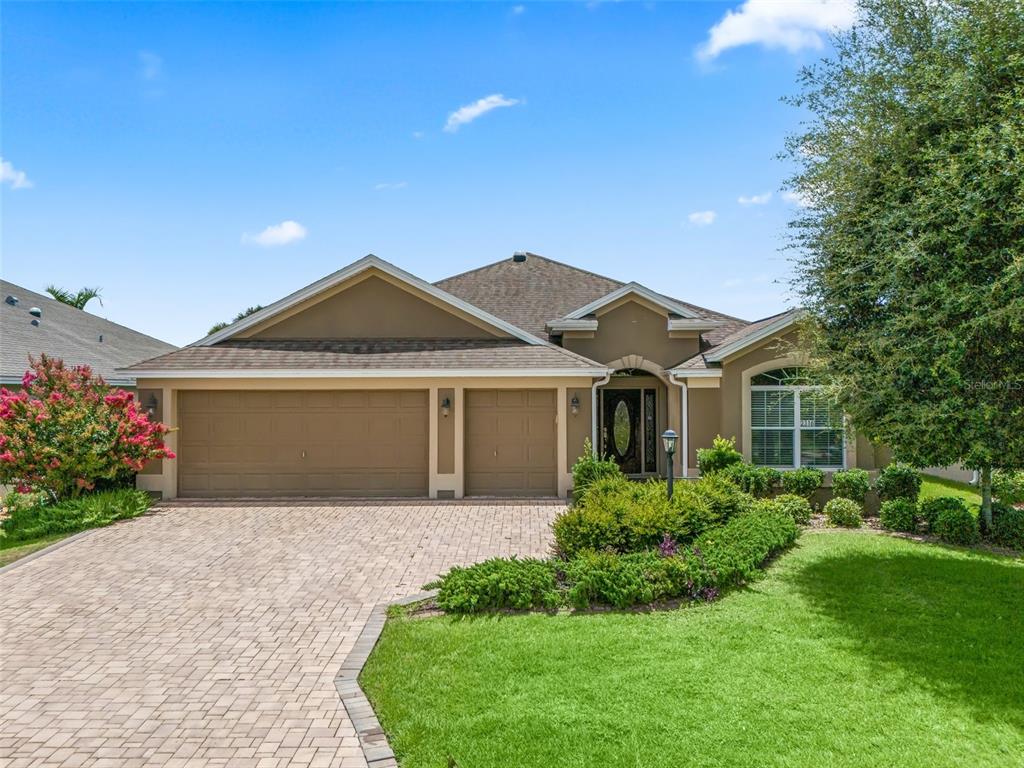 a front view of a house with a garden and yard