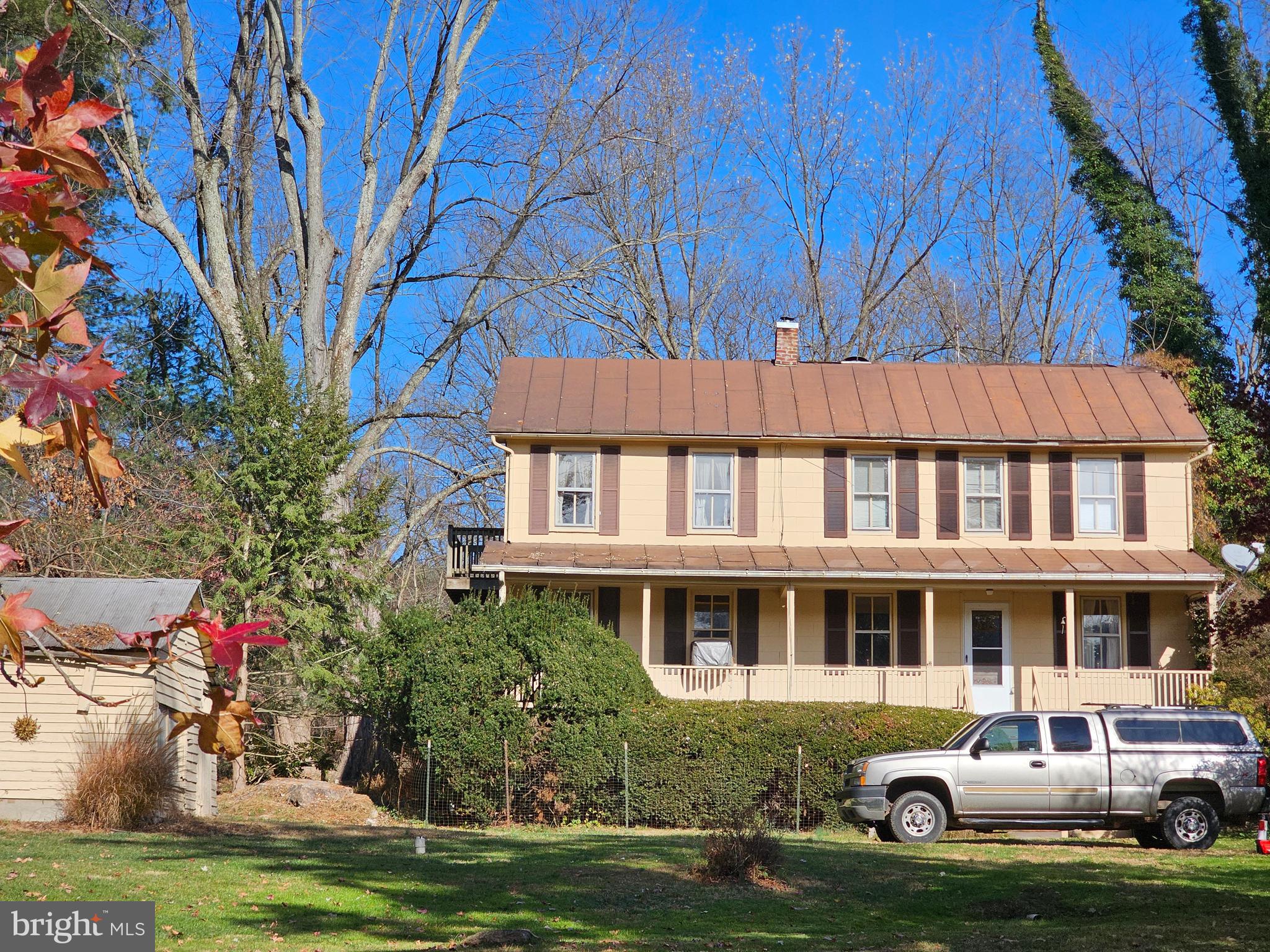 a front view of a house with a garden and trees