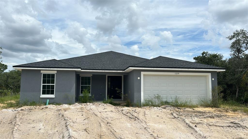 a front view of a house with a yard and garage