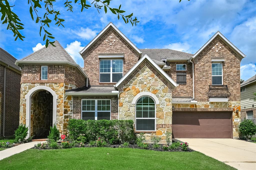 This charming two-story house features a beautiful blend of brick and stone on the exterior, creating an inviting and timeless appeal. The rich, earthy tones of the brick are complemented by the natural texture of the stone, adding a sophisticated touch to the home’s facade.