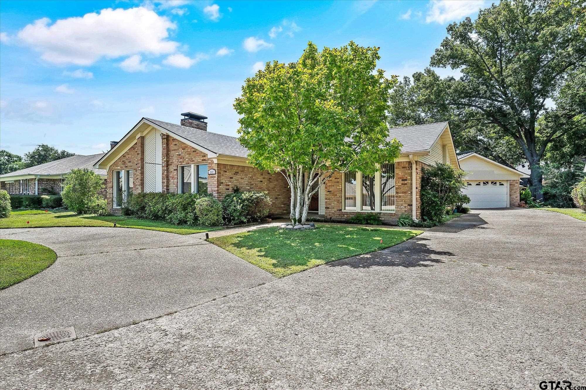 a front view of a house with yard and green space