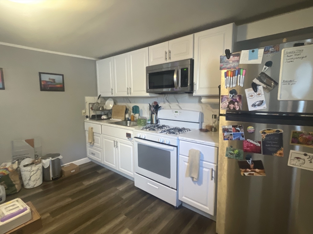 a kitchen with stainless steel appliances a stove microwave and sink