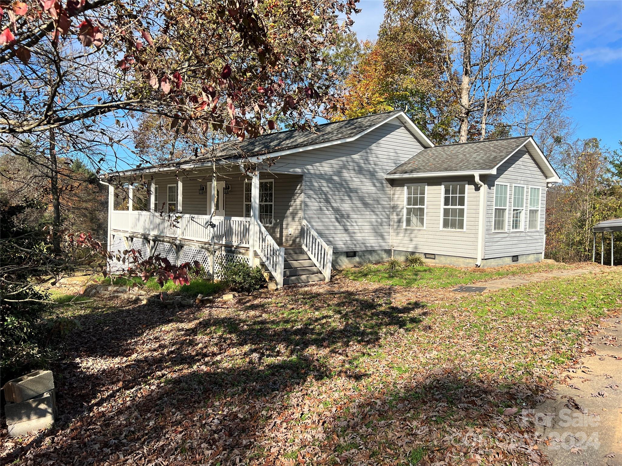 a view of a yard in front of a house with large tree