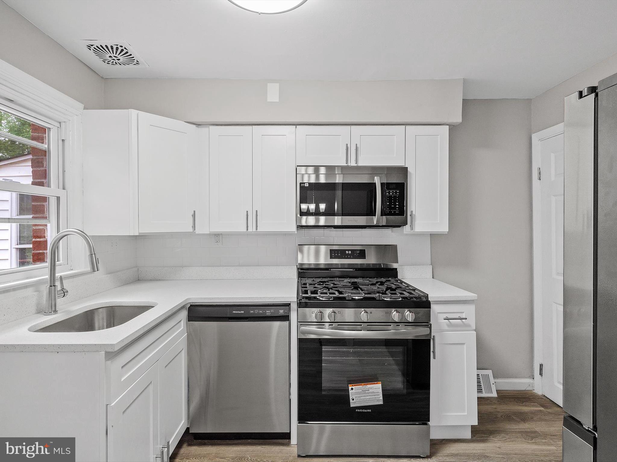 a kitchen with cabinets a sink and steel appliances