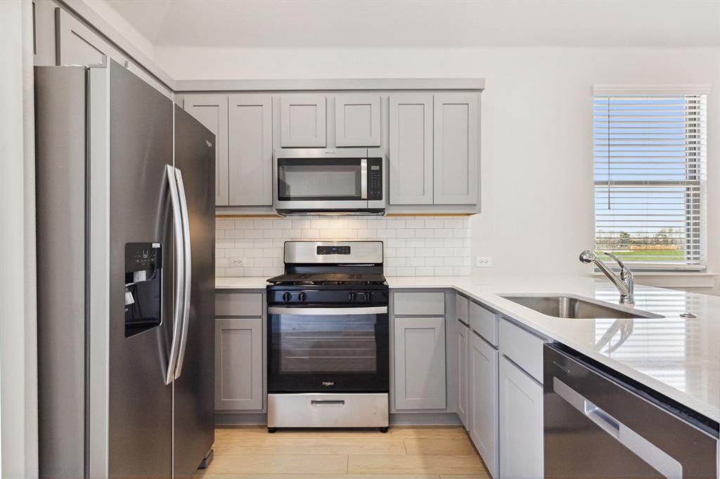 a kitchen with stainless steel appliances granite countertop a refrigerator stove and sink