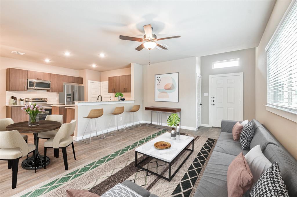 a living room with furniture a kitchen view and a chandelier