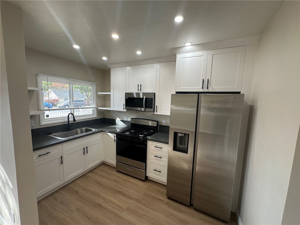 a kitchen with granite countertop stainless steel appliances cabinets a sink and a window