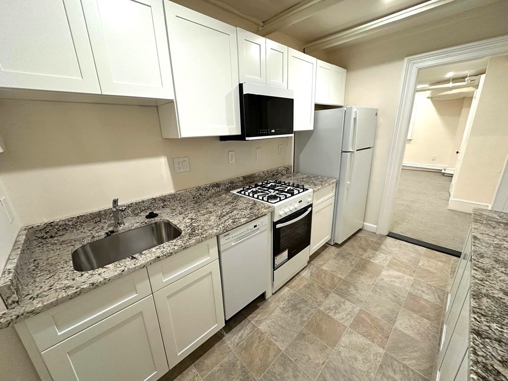 a kitchen with stainless steel appliances granite countertop a stove a sink and a refrigerator