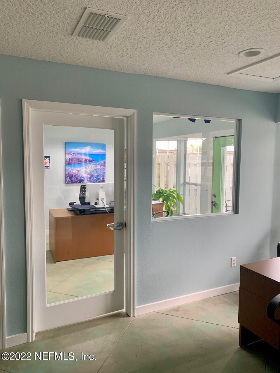 a view of a hallway with two painting on the wall and a window