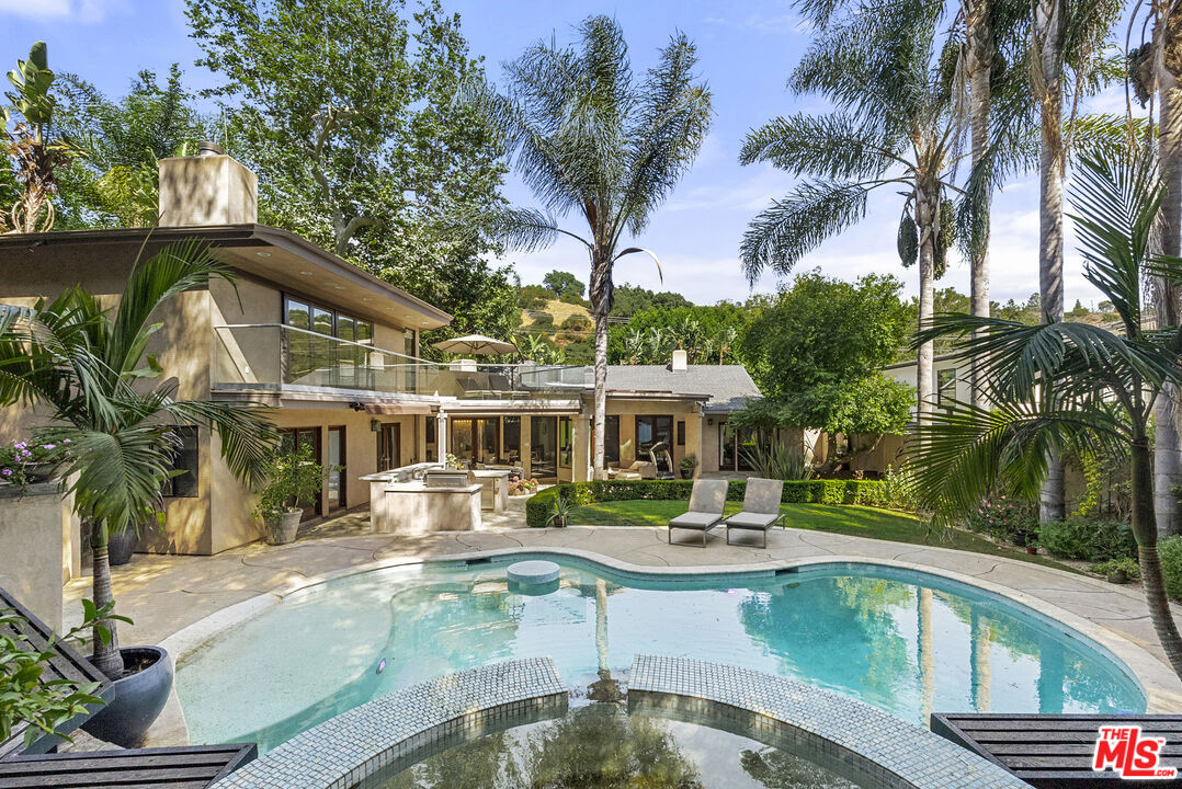 a house view with a swimming pool and sitting area