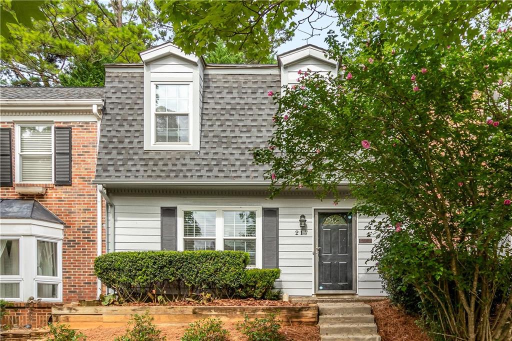 a front view of a house with a tree