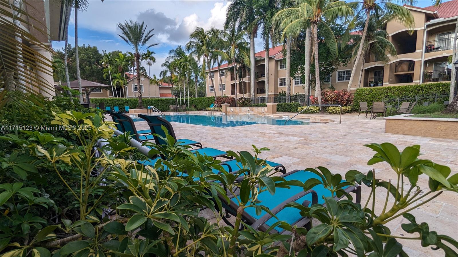 a front view of multi story residential apartment building with yard and outdoor seating