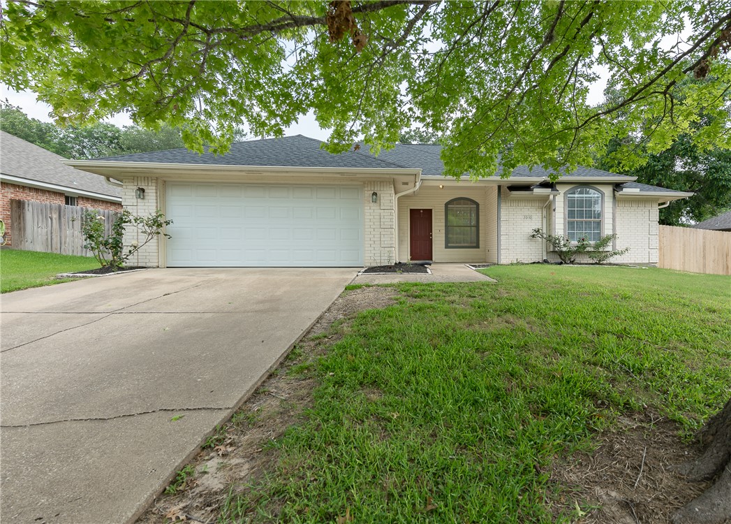 Ranch-style home with a front lawn and a garage