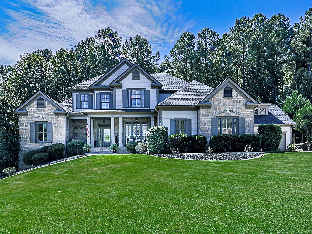 a front view of a house with a yard and trees