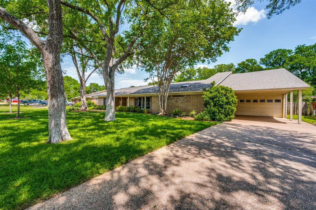 a front view of a house with a yard and trees