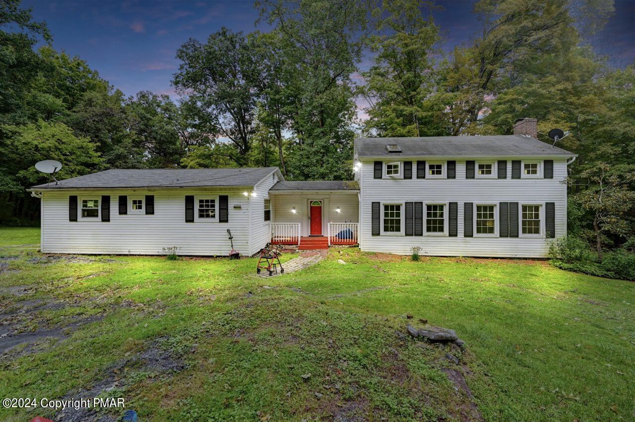 a front view of a house with yard and green space