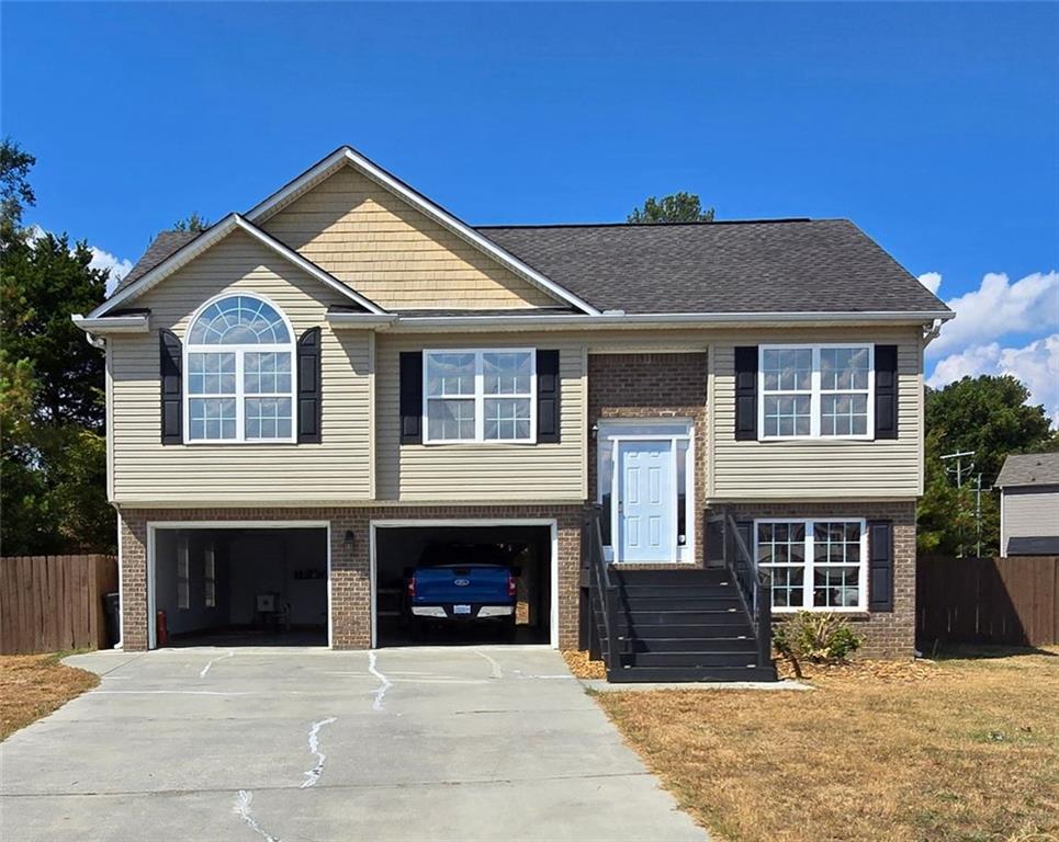 a front view of a house with yard and parking