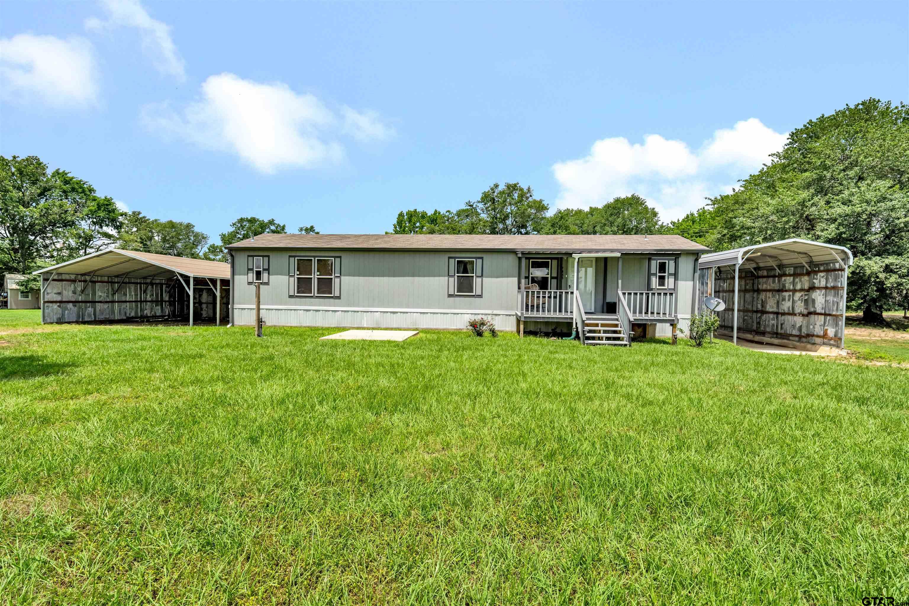 a view of a house with a yard and sitting area